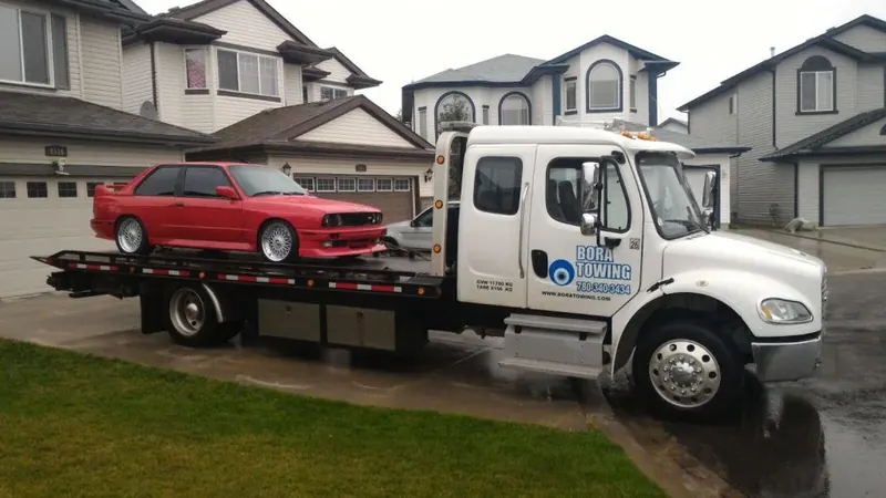 Bora Towing flatbed transporting red classic BMW M3 in Edmonton residential area