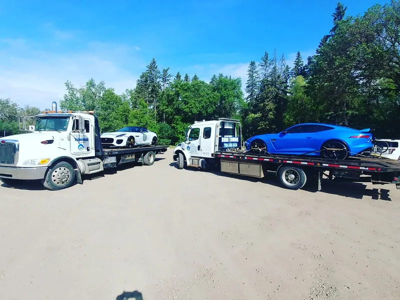 Bora Towing flatbeds transporting two Jaguar F-Type sports cars in Edmonton
