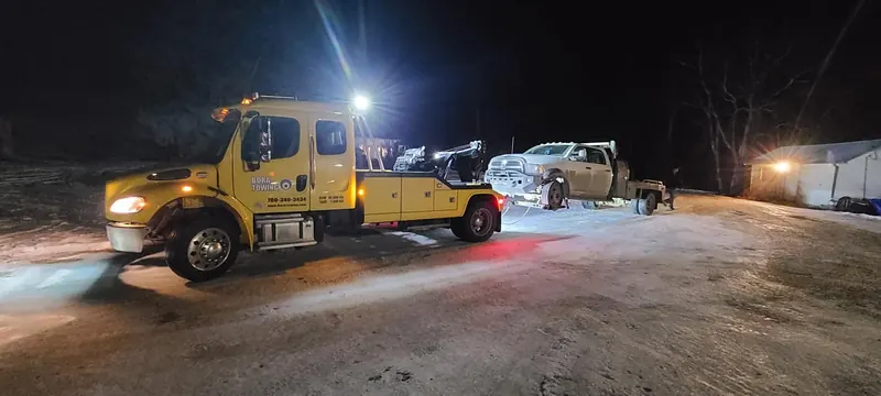 Bora Towing yellow wrecker on night recovery operation in winter Edmonton