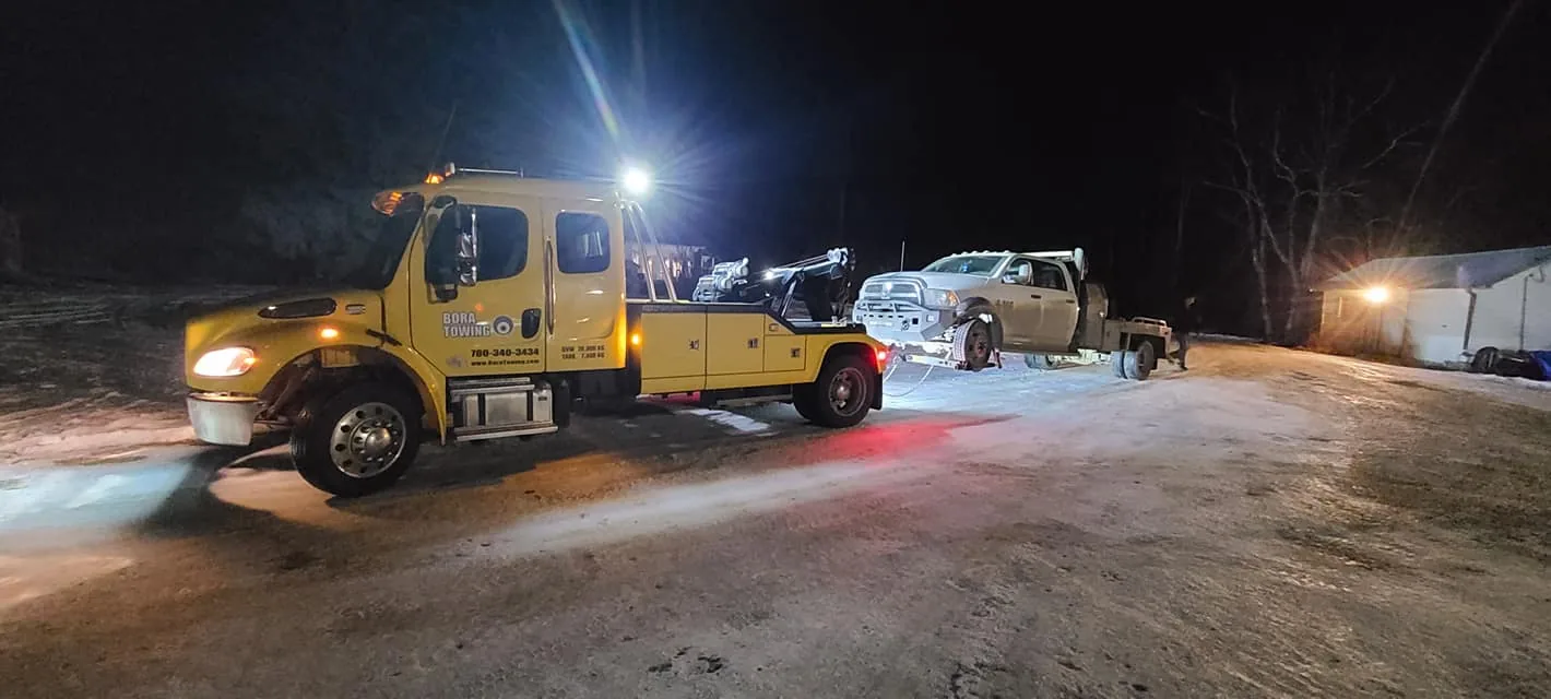 Bora Towing yellow wrecker on a night pickup-truck recovery in winter Edmonton
