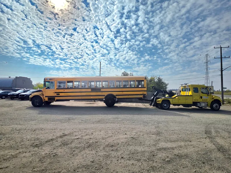 Bora Towing yellow wrecker recovering yellow school bus in Edmonton