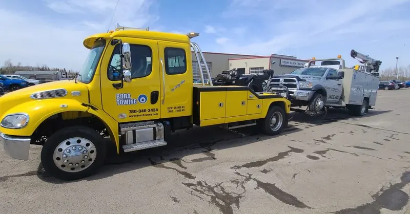 Bora Towing yellow wrecker towing silver pickup truck in Edmonton